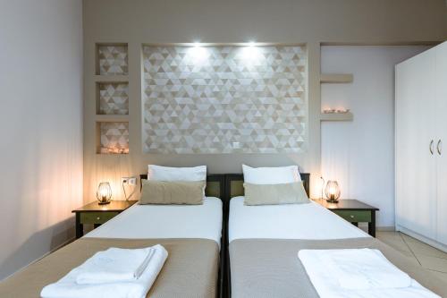 two beds in a room with white walls at Gelina Apartments in Plataniás