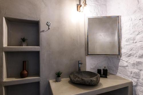 a bathroom with a sink and a mirror at Mykonos Supreme Comfort Suites & Villas in Kalafatis