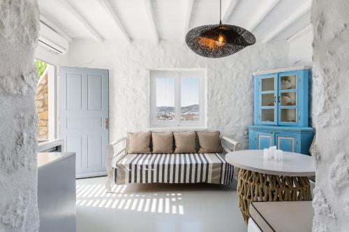 a living room with a couch and a table at Mykonos Supreme Comfort Suites & Villas in Kalafatis