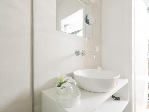 uma casa de banho branca com um lavatório e um espelho em Ipsmiller Appartements em Schrattenberg
