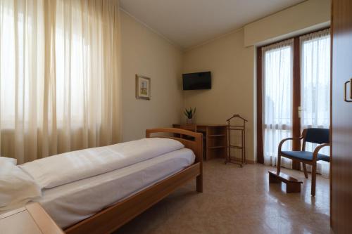 een slaapkamer met een bed, een bureau en een raam bij Casa Vacanza - Casa del Padre Nascimbeni in Torri del Benaco