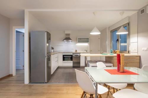 a kitchen and dining room with a table and a refrigerator at Ponferrada Castillo in Ponferrada
