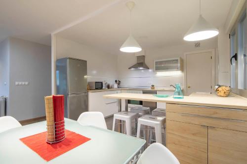 a kitchen with white counters and white stools in it at Ponferrada Castillo in Ponferrada