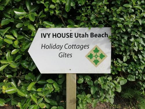 un panneau indiquant iv maison avec feux de camp de vacances sur la plage dans l'établissement Ivy House Utah Beach, à Sainte-Marie-du-Mont