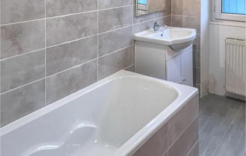 uma casa de banho com uma banheira branca e um lavatório. em 4 Bedroom Amazing Home In Champmillon em Champmillon