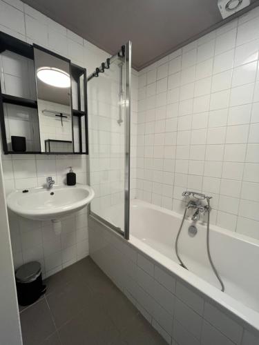 een badkamer met een bad, een wastafel en een douche bij Landzicht Vakantiehuis aan de Fluessen in Elahuizen