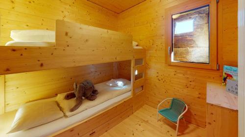 a bedroom with two bunk beds in a log cabin at Mountain Cabin Mutten-Graubünden in Mutten