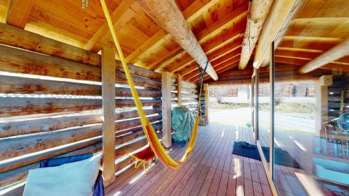 a porch of a wooden cabin with a hammock at Mountain Cabin Mutten-Graubünden in Mutten