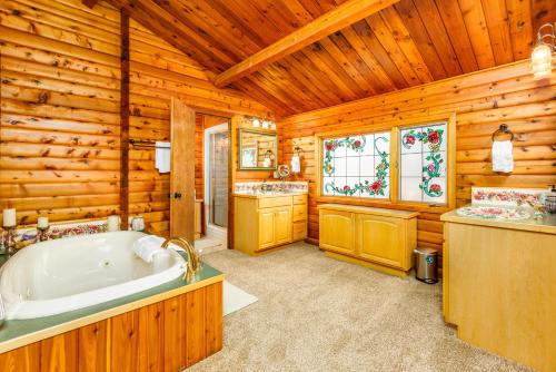 a wooden bathroom with a tub and a sink at Sand Lake View House in Anchorage