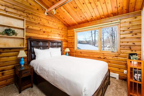 a bedroom with a bed in a log cabin at Sand Lake View House in Anchorage