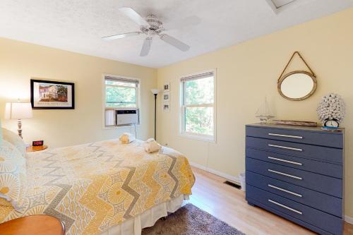 a bedroom with a bed and a dresser and a ceiling fan at Absolute Leelanau in Glen Arbor