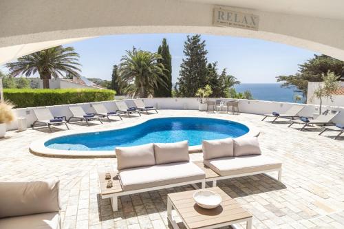 a swimming pool with lounge chairs and a table at Casa Oceanis in Salema