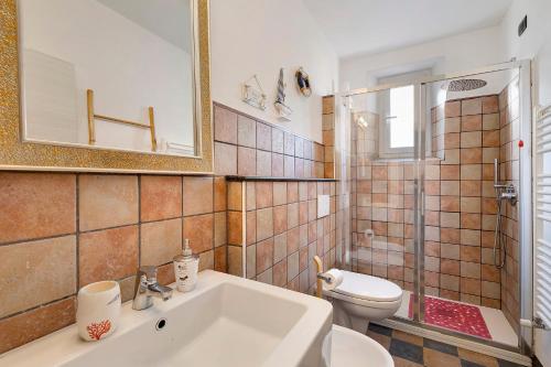 bagno con lavandino, servizi igienici e specchio di 4 Passi Mare a Finale Ligure