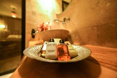 - une salle de bains avec 2 bouteilles de savon sur une assiette dans l'établissement Louis Cappadocia, à Uçhisar