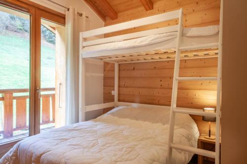 une chambre avec un lit superposé et une fenêtre dans l'établissement ALTAKA 5, à Morzine