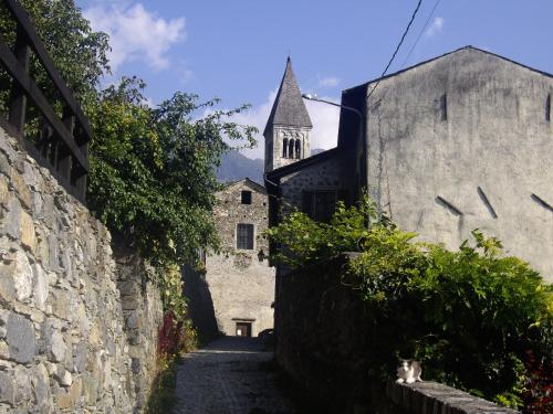 an alley in a castle with a church in the background at Casa Barbóla in Sondalo
