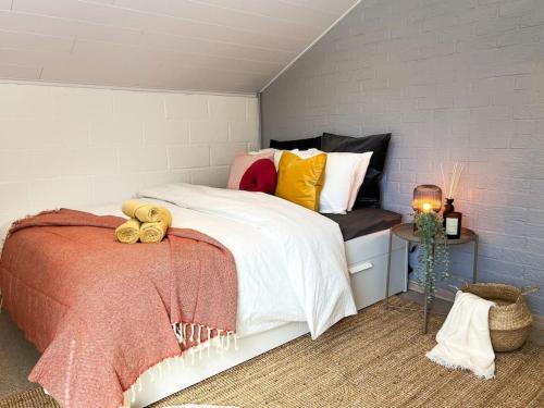 een slaapkamer met een bed en een bank met kussens bij Clémentine in Theux