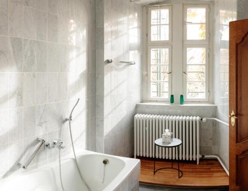een badkamer met een bad, een raam en een radiator bij Schlosshotel Erwitte in Erwitte