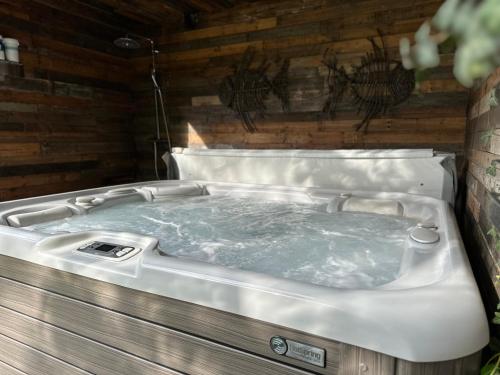 eine Whirlpool-Badewanne in einem Zimmer mit Holzwänden in der Unterkunft Sweetwater Privé Wellness in Oud-Heverlee