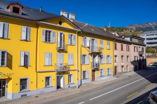 a yellow building on the side of a street at Luxury 3 bedroom apartment - old town of Sion in Sion