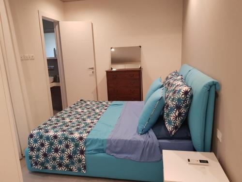 een kleine slaapkamer met een blauw bed en een dressoir bij Costa del Sole Furci in Furci Siculo