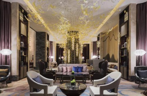 a lobby with a couch and chairs and a chandelier at Wanda Realm Changzhou in Changzhou