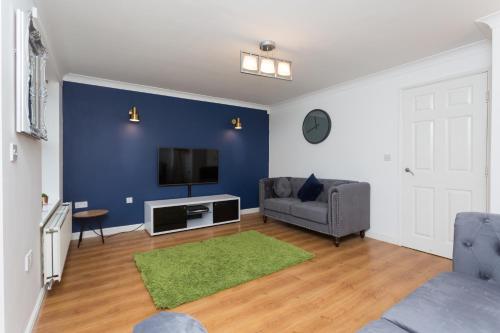 a living room with a couch and a tv at Great Park Townhouse in Preston