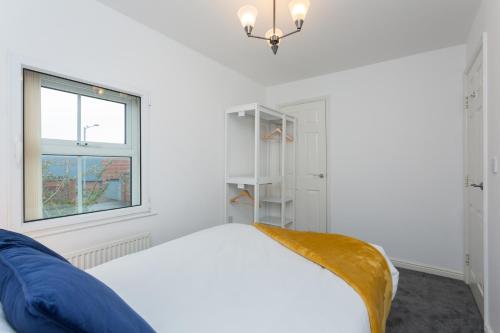 biała sypialnia z łóżkiem i oknem w obiekcie Great Park Townhouse w mieście Preston