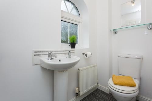 łazienka z umywalką, toaletą i oknem w obiekcie Great Park Townhouse w mieście Preston