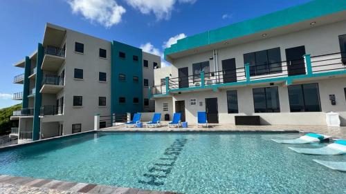 a swimming pool in front of a building at Hillsboro Suites & Residences Condo Hotel, St Kitts in Basseterre