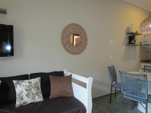 a living room with a couch and a mirror on the wall at Ilha Flat Hotel Suíte Bella - 4207 - Ilhabela in Ilhabela