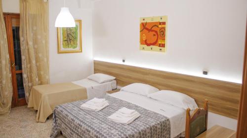 CapursoにあるColazione Inclusa - B&B Meteoraのベッド2台とテーブルが備わるホテルルームです。