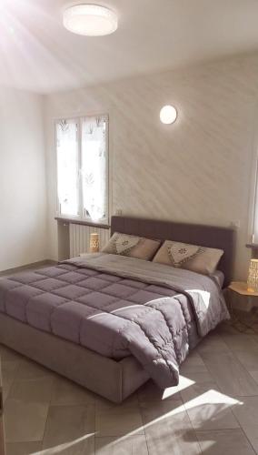 ein Schlafzimmer mit einem großen Bett mit einer lila Decke in der Unterkunft LONATE SUITE in Lonate Ceppino