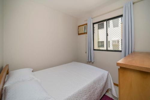 Habitación pequeña con cama y ventana en Aluguel Apartamento 2 quartos 100m Mar Bombas/SC, en Bombinhas
