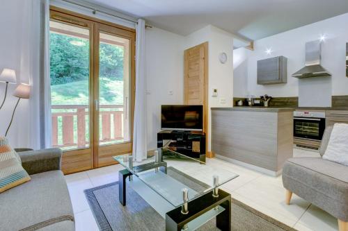 un salon avec un canapé et une table en verre dans l'établissement ALTAKA 5, à Morzine