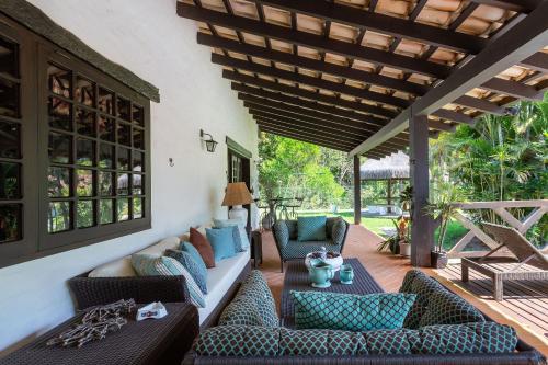 a living room with couches and chairs on a patio at Sítio com piscina, área arborizada e lazer in Jacareí