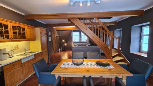 eine Küche mit einem Holztisch und blauen Stühlen in der Unterkunft Appartements im "Landhaus am Frohnauer Hammer" in Annaberg-Buchholz
