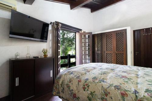 a bedroom with a bed and a flat screen tv at Sítio com piscina, área arborizada e lazer in Jacareí