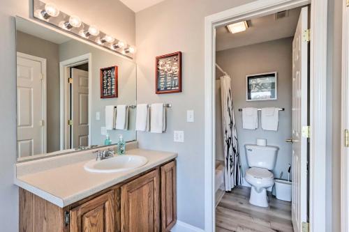 a bathroom with a sink and a toilet at Fireplace and Grill Bright Lake Ozark Condo! in Lake Ozark