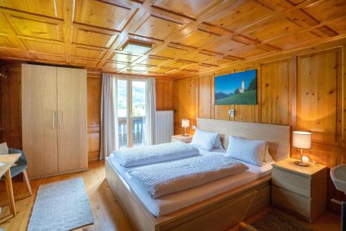 sypialnia z dużym łóżkiem i drewnianym sufitem w obiekcie Ferienhaus Fratte w mieście Schruns