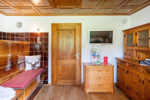 Pokój z drewnianymi drzwiami i telewizorem w obiekcie Ferienhaus Fratte w mieście Schruns