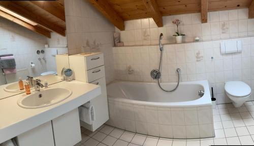 ein Badezimmer mit einer Badewanne, einem Waschbecken und einem WC in der Unterkunft Ferienwohnung Gruber in Teisendorf