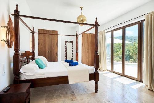 1 dormitorio con cama con dosel y ventana grande en Exclusive Luxury Villa South Facing Vista De Muntanya 6 Bedrooms A Few Minutes Drive To The Beach San Jose, en Sant Josep de sa Talaia