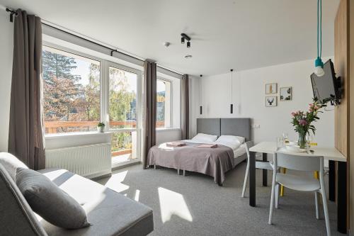 1 dormitorio con cama, escritorio y mesa en Villa Alpina, en Szklarska Poręba