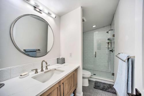 ein weißes Badezimmer mit einem Waschbecken und einem Spiegel in der Unterkunft Castle Rock Cottage - Walk to Town! in Castle Rock