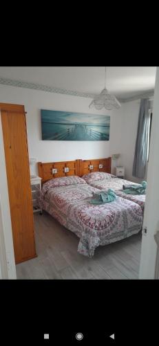 a bedroom with a large bed with a wooden headboard at Dunes to explore and relax right by the desert wifi in Corralejo