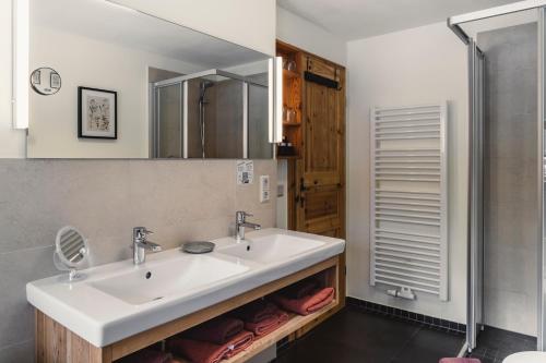ein Bad mit einem Waschbecken und einem Spiegel in der Unterkunft Altsächsischer Gasthof Kleines Vorwerk in Sayda