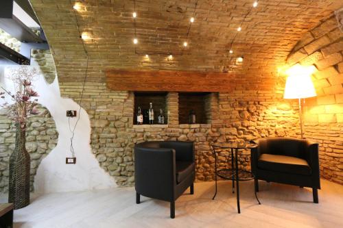 a bar with two chairs and a stone wall at PETITE MAISON in Lanciano