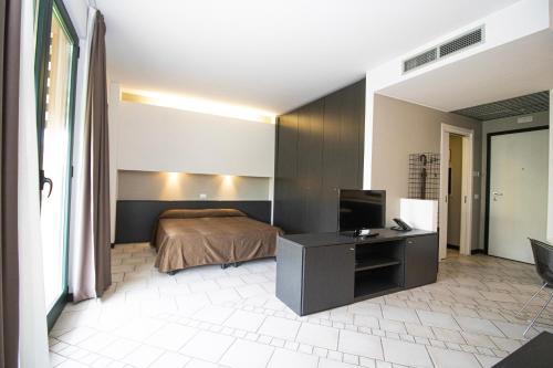 CasAlbergo - Superior Lake Apartments في كاستيلّيتّو سوبرا تيسان: غرفة نوم فيها سرير وتلفزيون