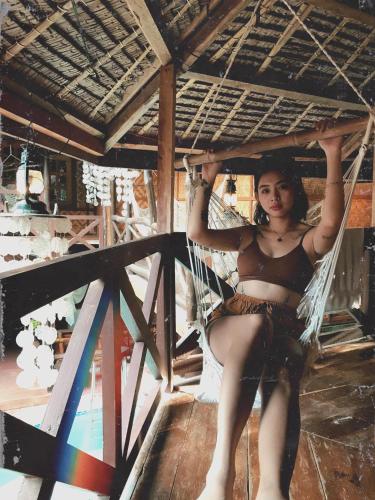 a woman is sitting in a hammock at Natura Vista in Panglao
